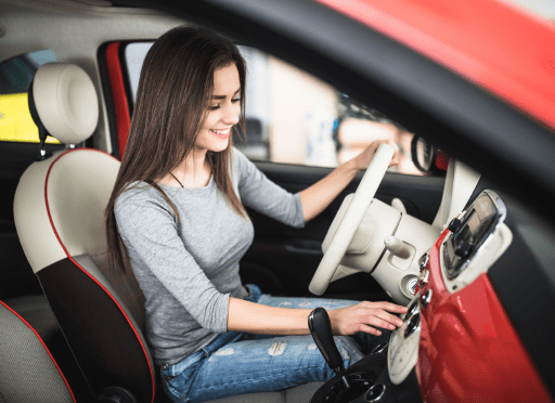 mujer conduciendo un coche rojo